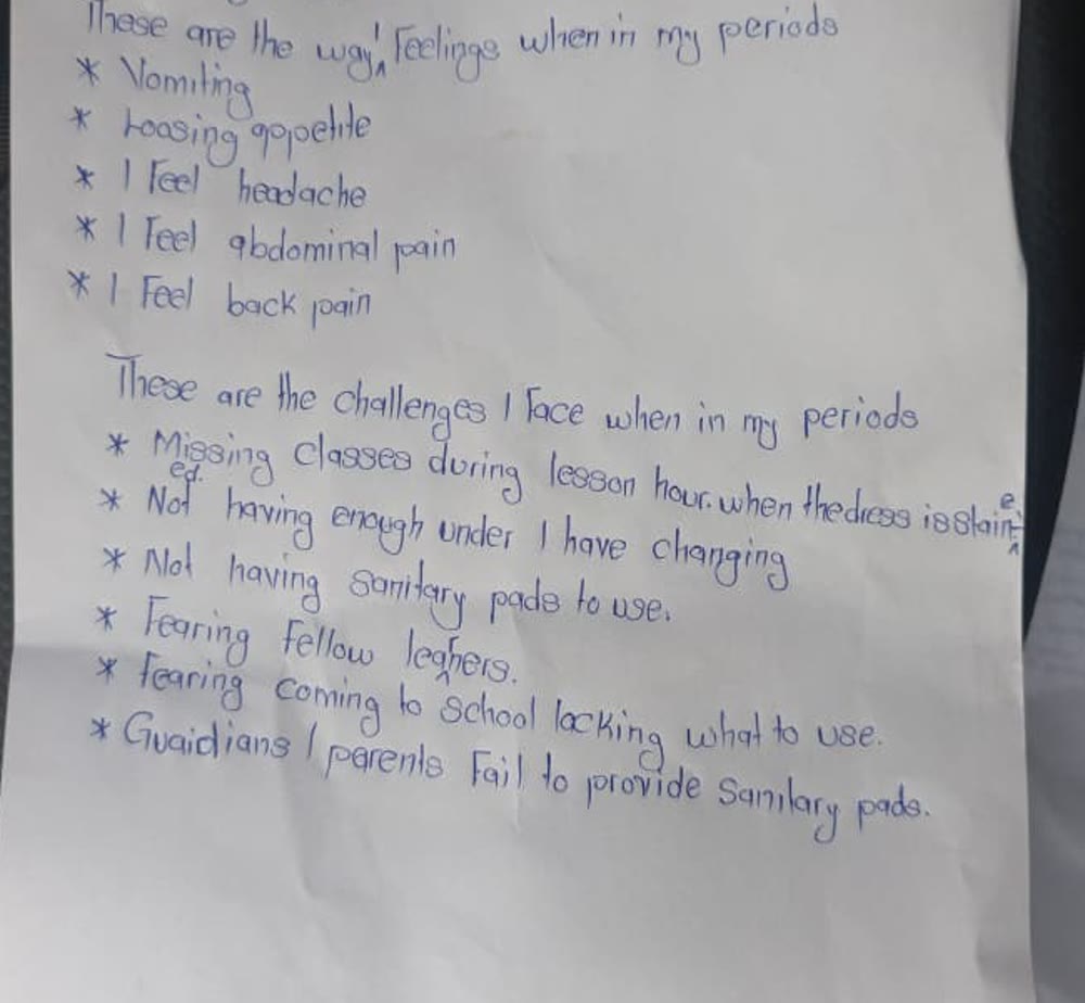 An anonymized handwritten student account describing menstrual symptoms, missed classes, stigma, and lack of sanitary pads