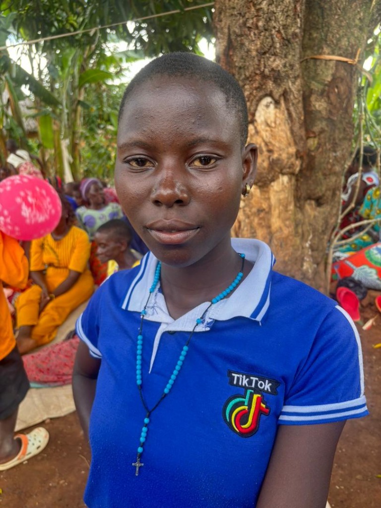 A young woman standing proudly, representing GVC's community development philosophy in rural Uganda