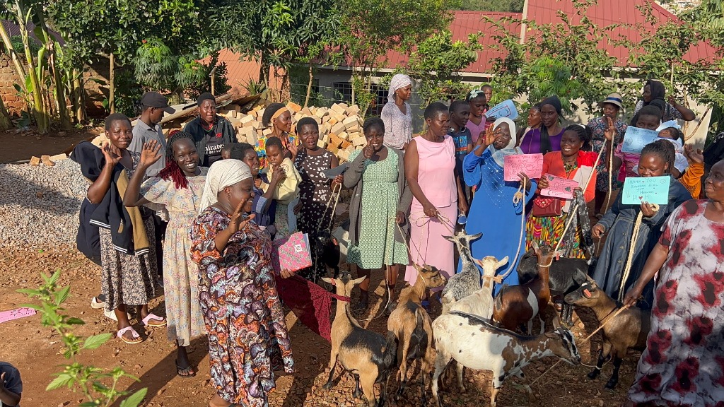 Ugandan families gathered with sponsored milk goats during a Global Village Connect goat distribution