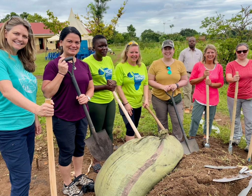 Global Village Connect volunteers with shovels preparing soil for planting in Uganda