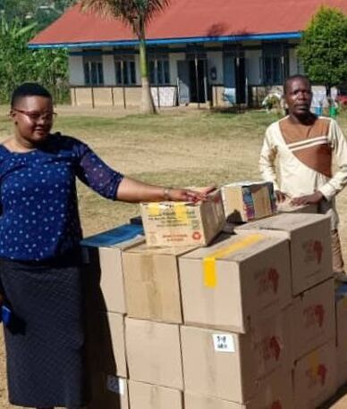 Local community leaders sorting through stack of books at Buyanga Primary School