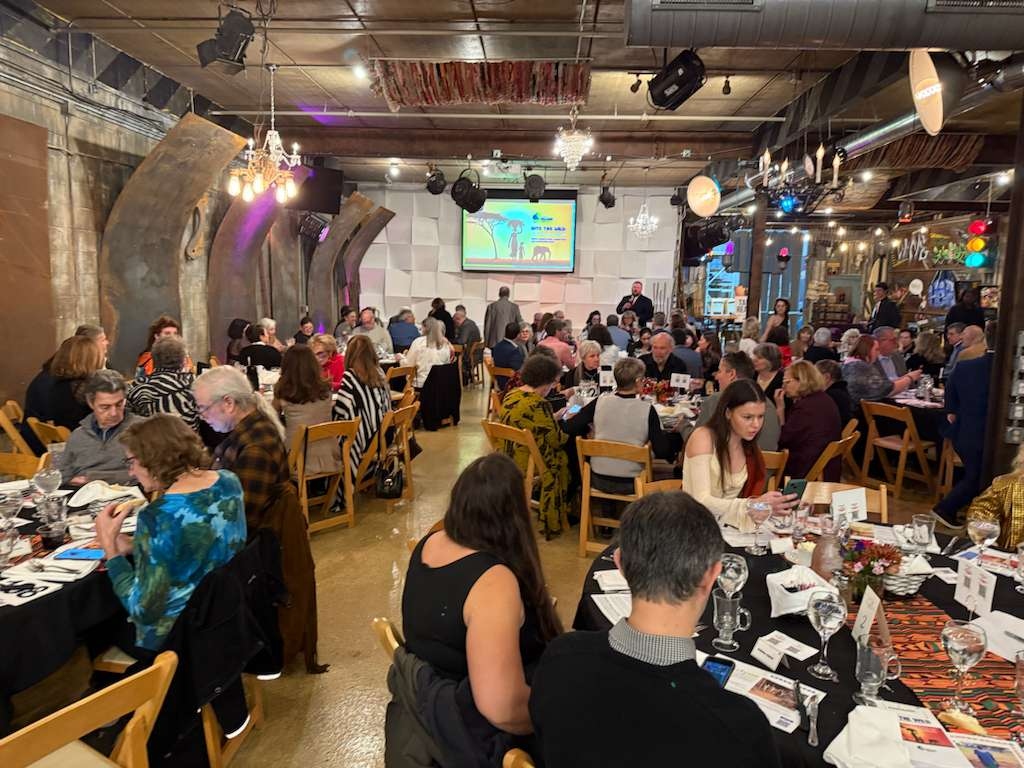 A wide view of the banquet hall with the Uganda impact presentation screen in the background