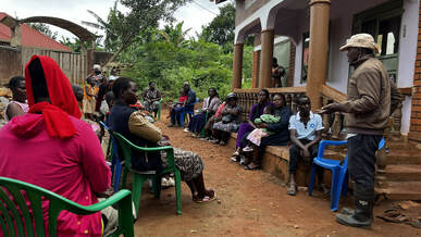 Families participate in veterinary officer-led training before goat distribution